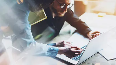 Ask Kodiak  Two colleagues interacting with a laptop.