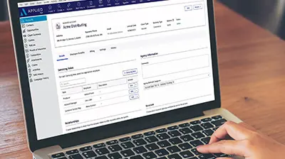 Applied Epic Has Moved to the Browser An open laptop with the screen on the Applied Epic website with a hand on the keyboard in the bottom right corner