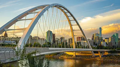 Armour Insurance Group View of an arched bridge going over a river with a city in the background