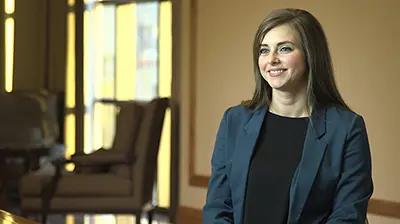 Fisher Brown Bottrell Insurance A young woman in a blue suit standing and smiling