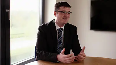 Prosperous Financial Planning A man in a suit responding to interview questions