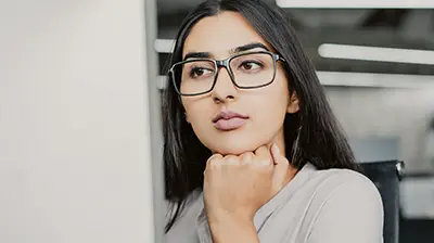 Hire Outlook: Generation Z and Insurance Careers A woman looking forward seriously while resting her fist under her chin