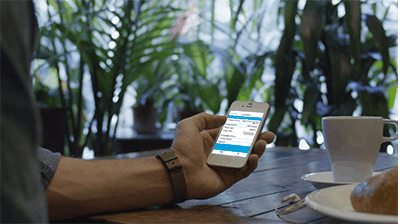 Applied MobileInsured A man reviewing something on his phone at a coffee shop